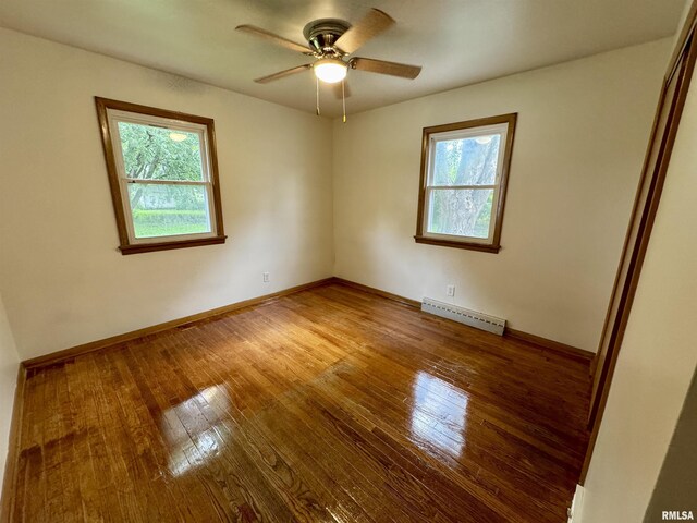 465 Fifer St, Galesburg, IL 61401 - unfurnished room featuring baseboard heating, hardwood / wood-style flooring, and a ceiling fan