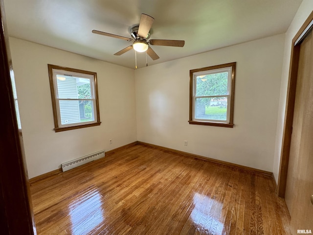465 Fifer St, Galesburg, IL 61401 - unfurnished bedroom featuring a baseboard heating unit, wood-type flooring, and ceiling fan
