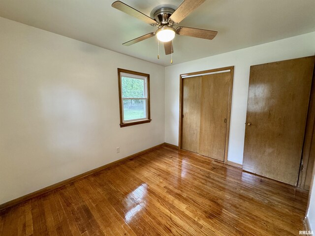 465 Fifer St, Galesburg, IL 61401 - unfurnished bedroom with two closets, light wood-style flooring, and a ceiling fan