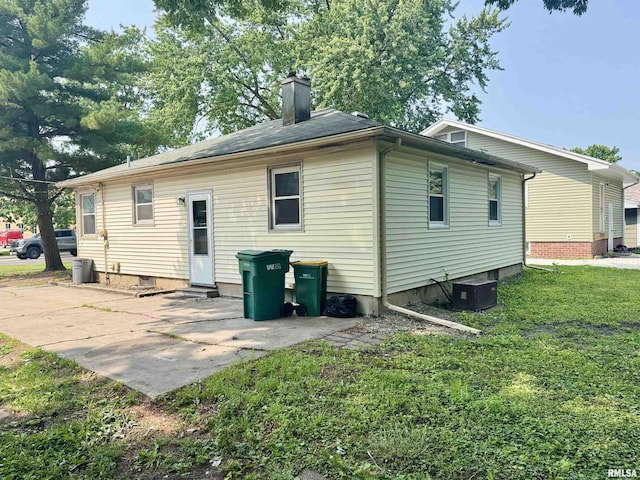 465 Fifer St, Galesburg, IL 61401 - rear view of house with a chimney, a patio, and a yard