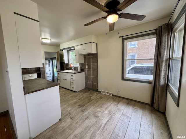 465 Fifer St, Galesburg, IL 61401 - kitchen featuring dark countertops, ceiling fan, white cabinets, and light wood finished floors