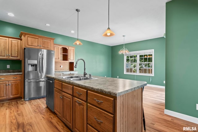 230 Possum Pass Ct, Sherman, IL 62684 - kitchen with appliances with stainless steel finishes, light wood-style floors, a kitchen island with sink, decorative light fixtures, and brown cabinets