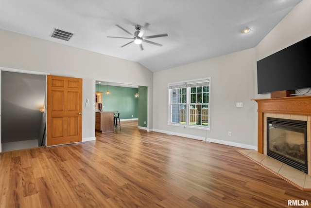 230 Possum Pass Ct, Sherman, IL 62684 - unfurnished living room with vaulted ceiling, a ceiling fan, a tiled fireplace, and wood finished floors