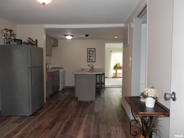 104 Henderson Rd, Knoxville, IL 61448 - kitchen with white appliances, dark wood-type flooring, a kitchen breakfast bar, light countertops, and a kitchen island with sink