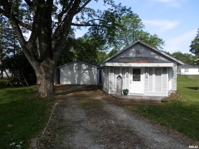 104 Henderson Rd, Knoxville, IL 61448 - view of front of home featuring dirt driveway, a detached garage, an outbuilding, and a front yard