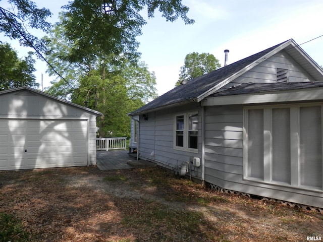 104 Henderson Rd, Knoxville, IL 61448 - view of home's exterior featuring an outdoor structure, a deck, a detached garage, and a shingled roof