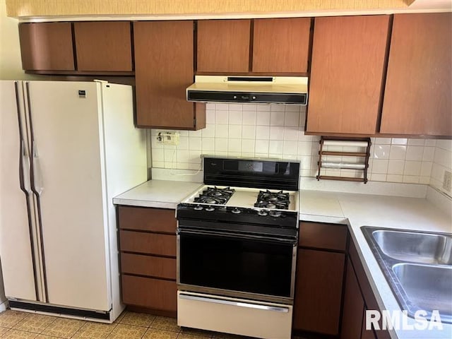 31 Glenwood Ln, Chatham, IL 62629 - kitchen featuring gas range oven, under cabinet range hood, freestanding refrigerator, and light countertops