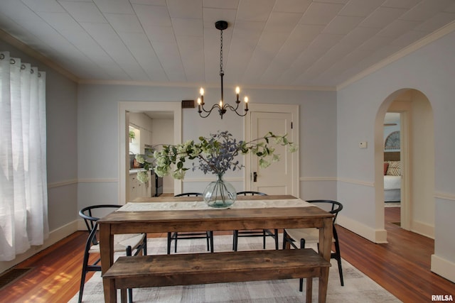 2204 Spring St, Quincy, IL 62301 - dining space featuring a chandelier, wood finished floors, arched walkways, and ornamental molding