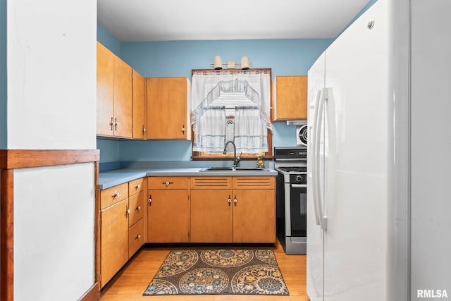 1537 N 4th St, Springfield, IL 62702 - kitchen with stainless steel gas stove, freestanding refrigerator, light wood-style flooring, and light countertops
