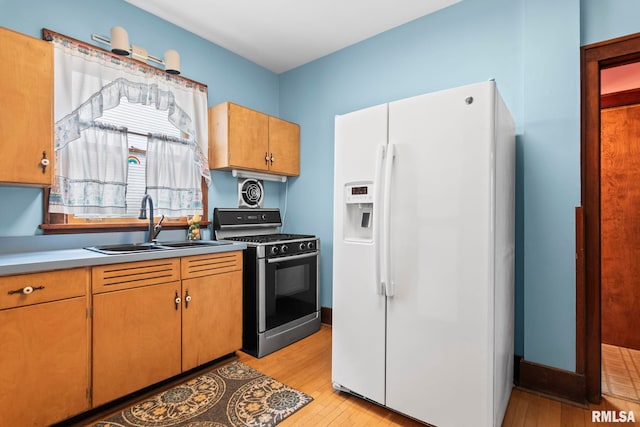 1537 N 4th St, Springfield, IL 62702 - kitchen featuring white refrigerator with ice dispenser, stainless steel range with gas cooktop, light wood-style floors, and light countertops