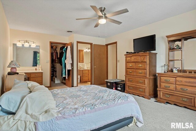 5309 Collins Way, Springfield, IL 62703 - bedroom featuring a walk in closet, light carpet, a closet, connected bathroom, and a ceiling fan