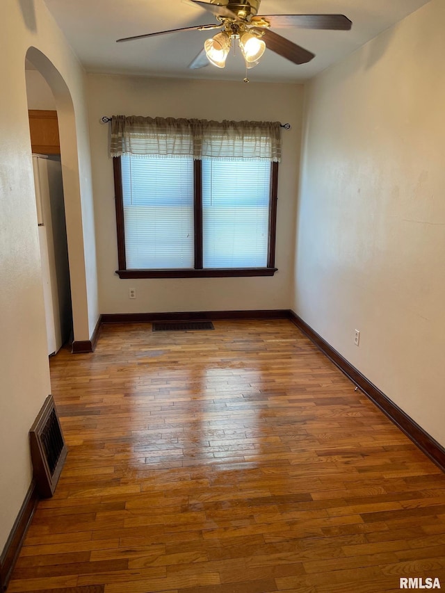 805 W Washington St, Pittsfield, IL 62363 - unfurnished room with arched walkways, wood-type flooring, and a ceiling fan