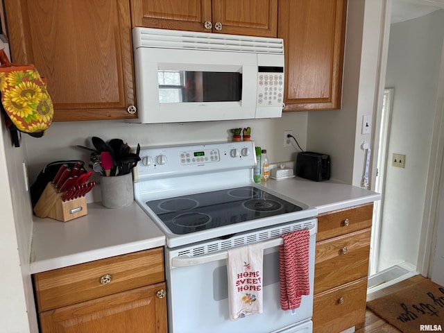 805 W Washington St, Pittsfield, IL 62363 - kitchen with white appliances, light countertops, and brown cabinetry