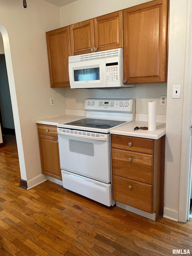 805 W Washington St, Pittsfield, IL 62363 - kitchen with white appliances, brown cabinets, arched walkways, and dark wood-style flooring