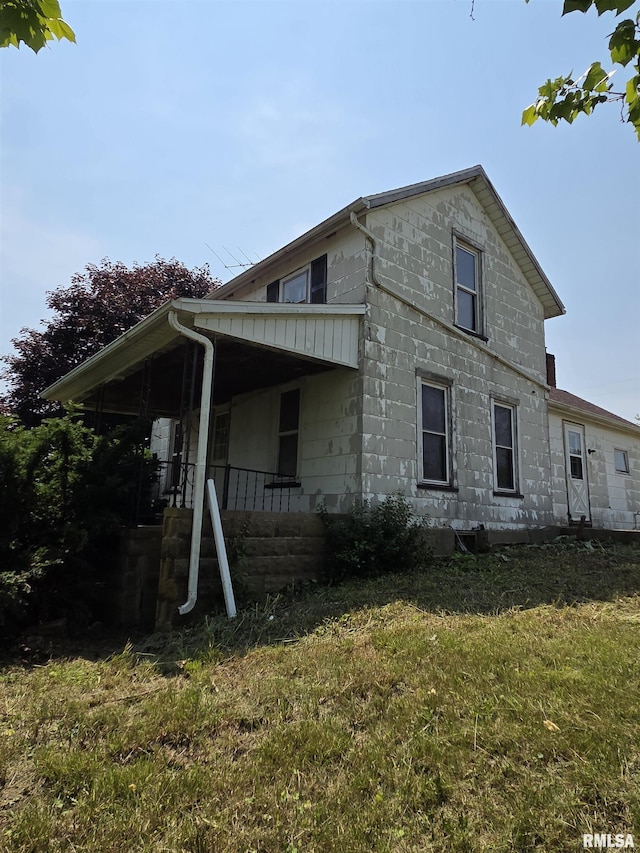 1355 Old Wagon Rd, Knoxville, IL 61448 - view of property exterior with a yard, concrete block siding, and a porch