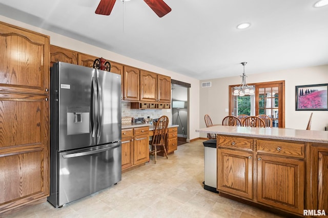 5313 Jaeger Dr, Springfield, IL 62711 - kitchen featuring stainless steel fridge, brown cabinetry, ceiling fan, pendant lighting, and light countertops
