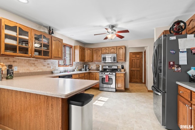 5313 Jaeger Dr, Springfield, IL 62711 - kitchen featuring appliances with stainless steel finishes, a peninsula, ceiling fan, light countertops, and brown cabinets