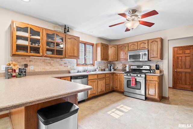 5313 Jaeger Dr, Springfield, IL 62711 - kitchen with appliances with stainless steel finishes, light countertops, glass insert cabinets, and backsplash
