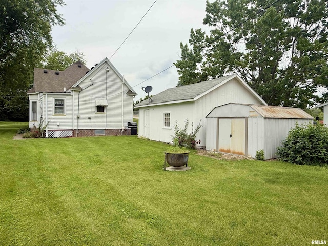 305 N Harshbarger St, Abingdon, IL 61410 - rear view of property with a shed, a lawn, and a shingled roof
