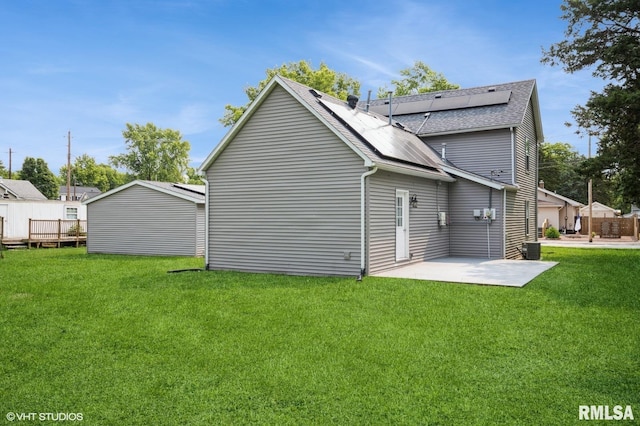 713 S Jackson St, Litchfield, IL 62056 - rear view of house featuring roof with shingles, a lawn, a patio, and solar panels