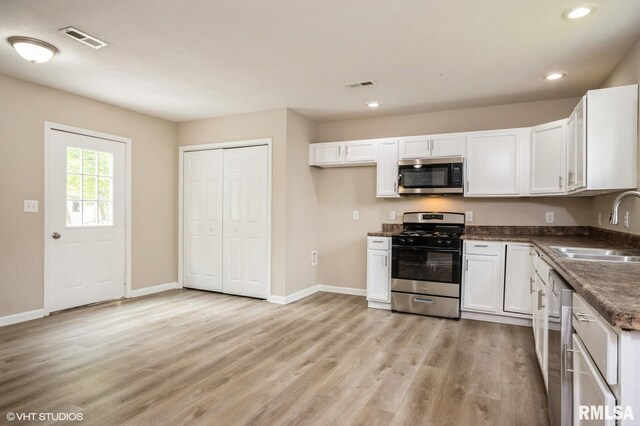 713 S Jackson St, Litchfield, IL 62056 - kitchen with appliances with stainless steel finishes, white cabinetry, light wood finished floors, and recessed lighting