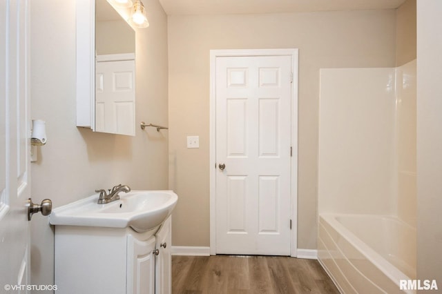 713 S Jackson St, Litchfield, IL 62056 - full bath featuring vanity, wood finished floors, and washtub / shower combination