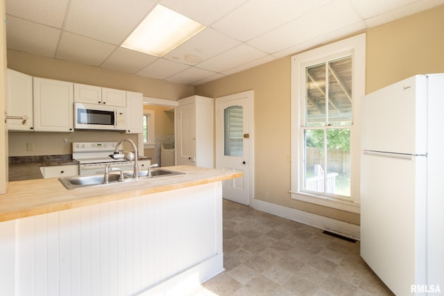 117 W Jefferson St, Macomb, IL 61455 - kitchen with white appliances, a peninsula, a paneled ceiling, white cabinets, and independent washer and dryer