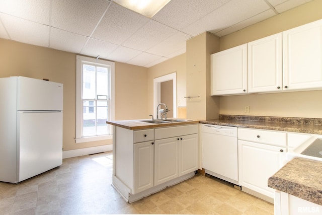 117 W Jefferson St, Macomb, IL 61455 - kitchen featuring white appliances, a drop ceiling, a peninsula, white cabinets, and light flooring