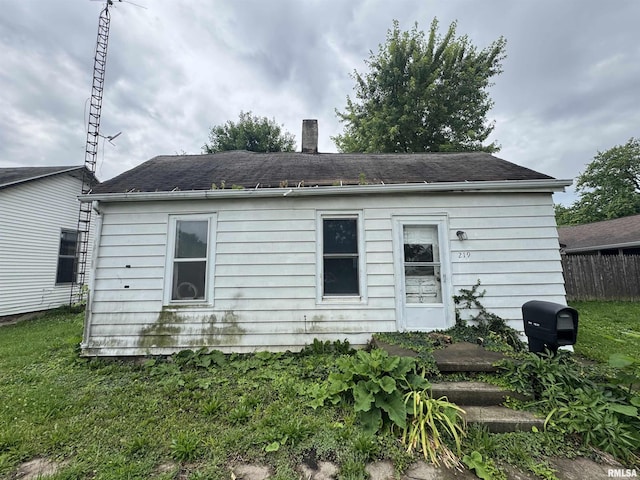 219 5th St, Lincoln, IL 62656 - rear view of house featuring a chimney and a shingled roof