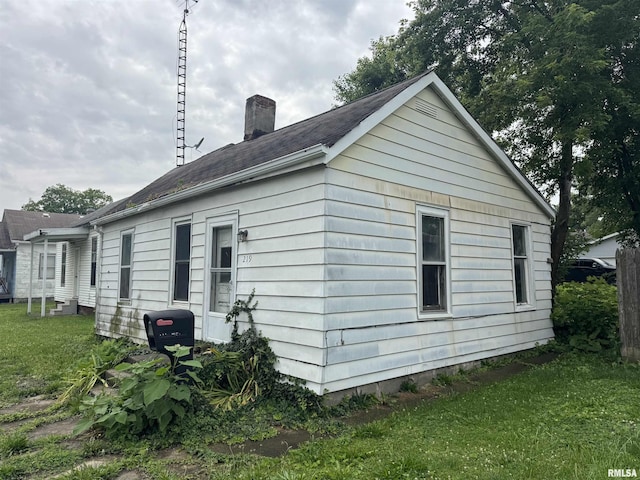 219 5th St, Lincoln, IL 62656 - view of side of property featuring a chimney and a lawn