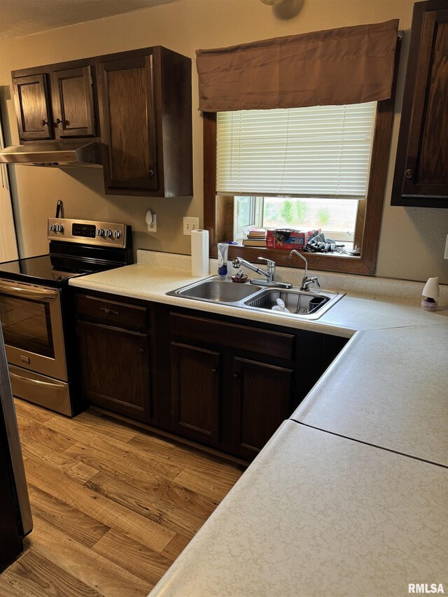 10333 Evergreen Dr, Manito, IL 61546 - kitchen with stainless steel electric range, under cabinet range hood, dark brown cabinetry, and light countertops