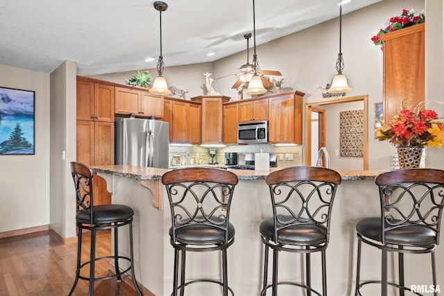 2308 Halifax Ave, Chatham, IL 62629 - kitchen with stainless steel appliances, vaulted ceiling, backsplash, wood finished floors, and hanging light fixtures