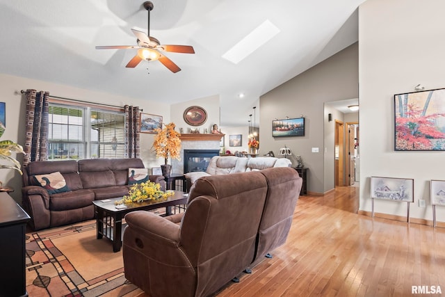 2308 Halifax Ave, Chatham, IL 62629 - living area with ceiling fan, a glass covered fireplace, light wood-type flooring, high vaulted ceiling, and a skylight