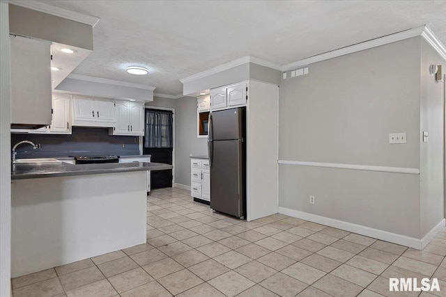 27 Twilight Ln, Springfield, IL 62712 - kitchen featuring freestanding refrigerator, crown molding, white cabinets, light tile patterned floors, and dark countertops