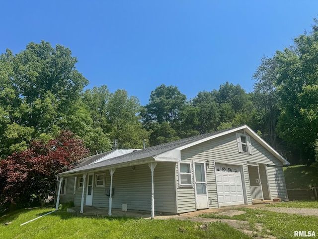 220 E Adams St, Petersburg, IL 62675 - view of property exterior featuring a yard, a detached garage, and covered porch