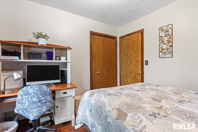 838 Hackberry Rd, Chatham, IL 62629 - bedroom featuring dark wood-style flooring, a closet, a textured ceiling, and built in desk