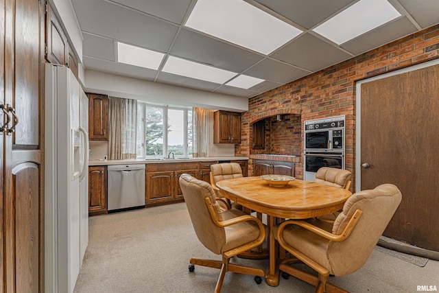 9320 Dawson Ln, Riverton, IL 62561 - dining space featuring a drop ceiling, brick wall, and light colored carpet