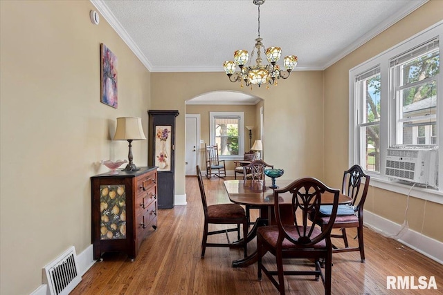 2141 S 4th St, Springfield, IL 62703 - dining room with arched walkways, wood finished floors, a textured ceiling, crown molding, and a chandelier