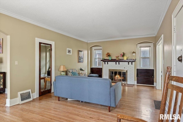 2141 S 4th St, Springfield, IL 62703 - living area featuring light wood-style flooring, a textured ceiling, arched walkways, a fireplace, and ornamental molding