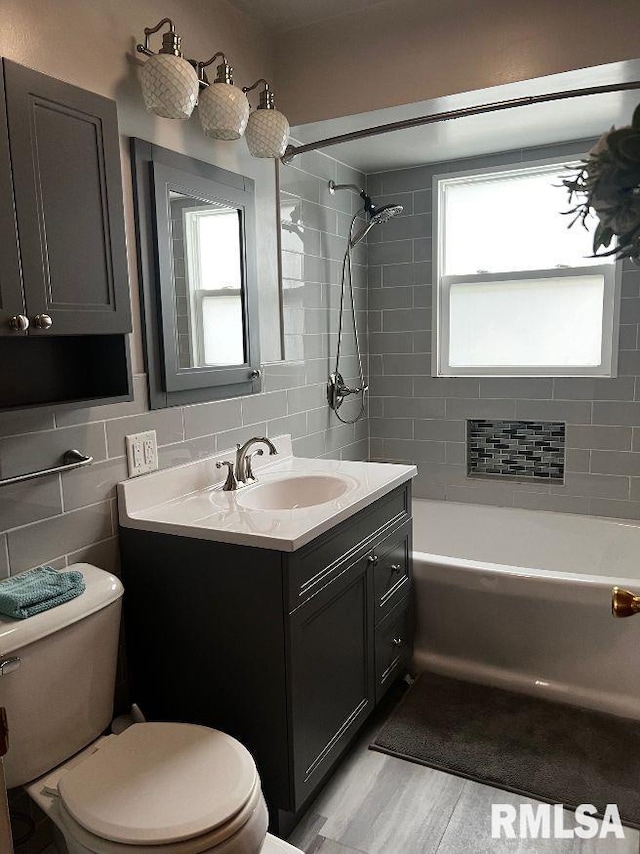 604 Eastman Ave Unit A, Springfield, IL 62702 - full bath featuring washtub / shower combination, vanity, wood finished floors, and tile walls