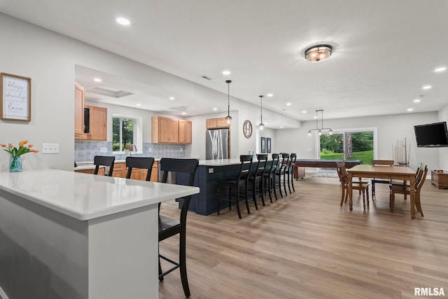 10 The Elms Ln, Springfield, IL 62712 - kitchen featuring freestanding refrigerator, a kitchen breakfast bar, light wood-type flooring, recessed lighting, and backsplash