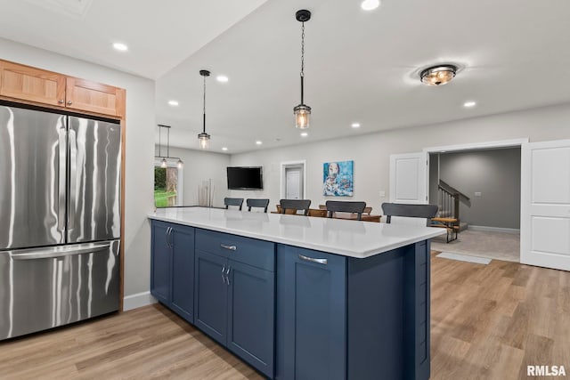 10 The Elms Ln, Springfield, IL 62712 - kitchen with freestanding refrigerator, a peninsula, blue cabinetry, light countertops, and light wood-type flooring