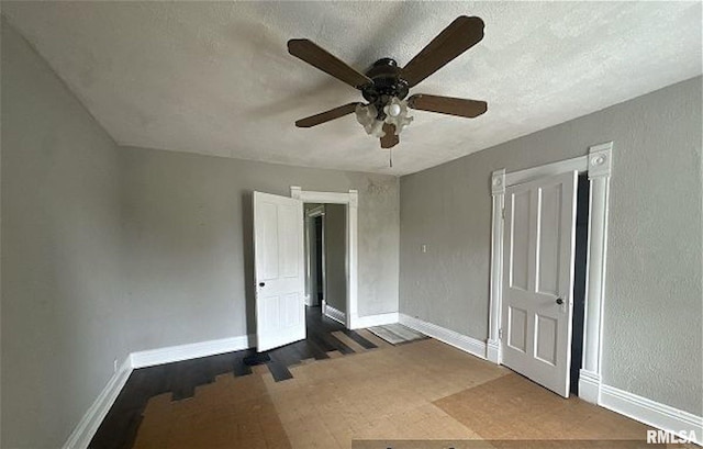 518 E 4th Ave, Monmouth, IL 61462 - unfurnished bedroom with a textured ceiling, ceiling fan, and wood finished floors