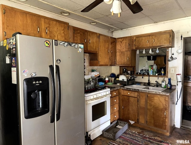 931 S A St, Monmouth, IL 61462 - kitchen featuring stainless steel fridge with ice dispenser, white range with gas stovetop, brown cabinetry, a paneled ceiling, and ceiling fan