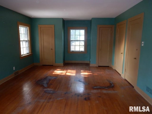 635 S Seigel St, Decatur, IL 62522 - unfurnished bedroom featuring multiple closets, wood finished floors, and multiple windows