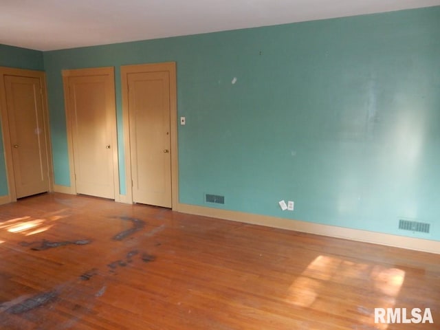 635 S Seigel St, Decatur, IL 62522 - unfurnished bedroom featuring two closets and wood finished floors