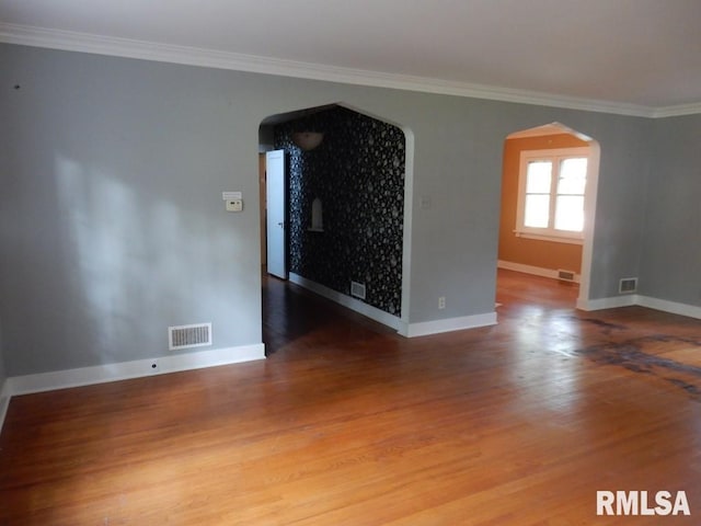 635 S Seigel St, Decatur, IL 62522 - unfurnished room featuring arched walkways, crown molding, and wood finished floors