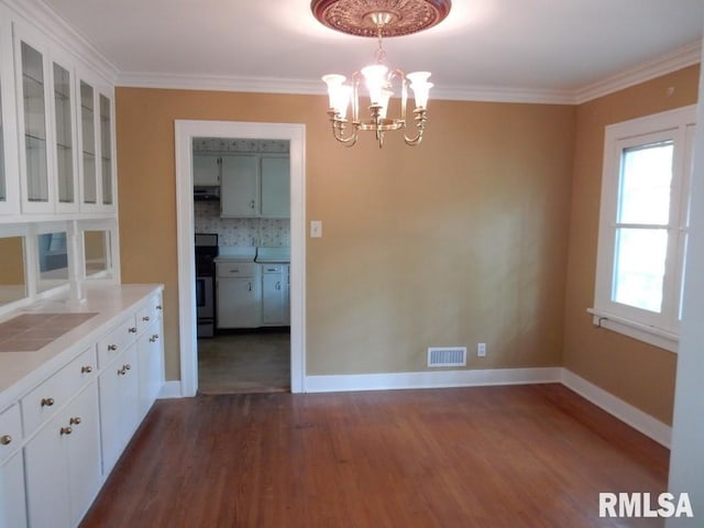 635 S Seigel St, Decatur, IL 62522 - unfurnished dining area with a chandelier, dark wood finished floors, and crown molding