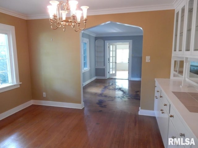 635 S Seigel St, Decatur, IL 62522 - unfurnished dining area featuring arched walkways, dark wood-type flooring, a chandelier, and crown molding