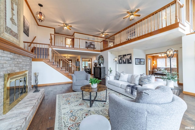 3939 Musholt Strasse Ln, Quincy, IL 62305 - living area featuring a brick fireplace, a ceiling fan, a high ceiling, stairs, and wood finished floors